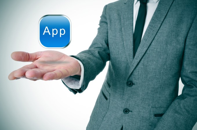 Man in suit flipping app in his hand.
