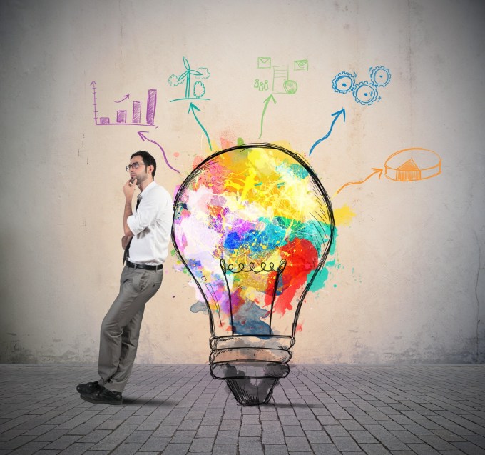 Business Intelligence concept picture: Guy leaning against a lightbulb with graphs drawn around the bulb.