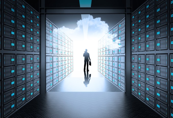 Man walking inside server room towards cloud.