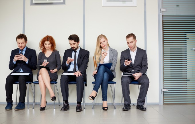 A group of young professionals on their smartphones.
