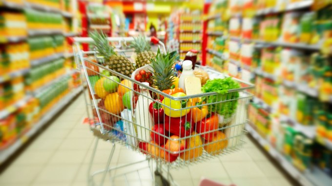 Image of grocery cart full of products in supermarket