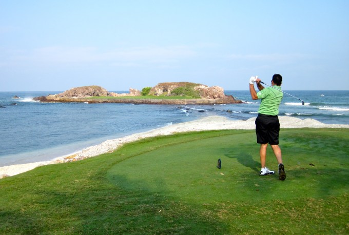 Man golfing on island.