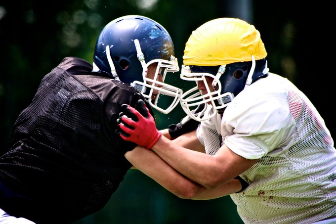 Two big football players wrestling for position.