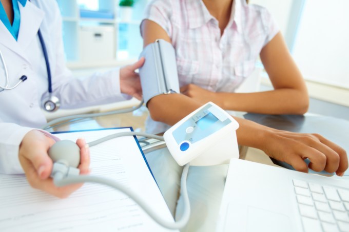 Close-up of tonometer by patient's arm during blood pressure measuring at medical consultation
