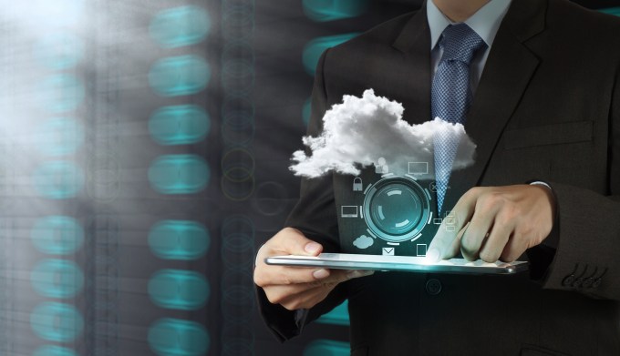 Man holding tablet with cloud hovering over it.