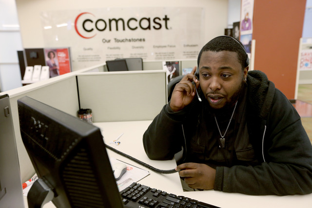 MIRAMAR, FL - FEBRUARY 13:  Gregory Bristol, a customer associate, speaks with a customer on the phone at a Comcast cable call center on February 13, 2014 in Miramar, Florida.  Today, Comcast announced a $45-billion offer for Time Warner Cable.  (Photo by Joe Raedle/Getty Images)