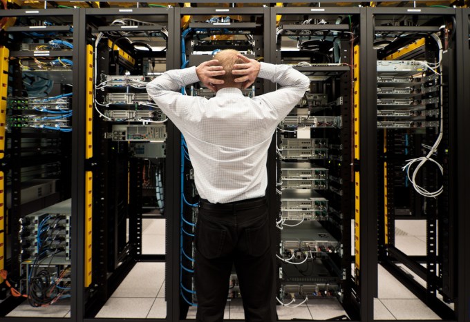 Man with hands on head looking at his servers.