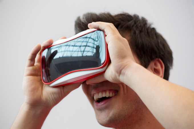 Andrew Nicholls demonstrates the latest version of a View-Master, a collaboration between Mattel and Google, at the Mattel showroom at the North American International Toy Fair, Saturday, Feb. 14, 2015, in New York. The new version of the classic toy uses Google's smartphone-based virtual reality solution, Cardboard. (AP Photo/Mark Lennihan)