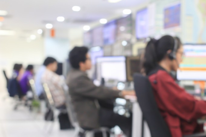 Blurred image of customer service people working at computers.