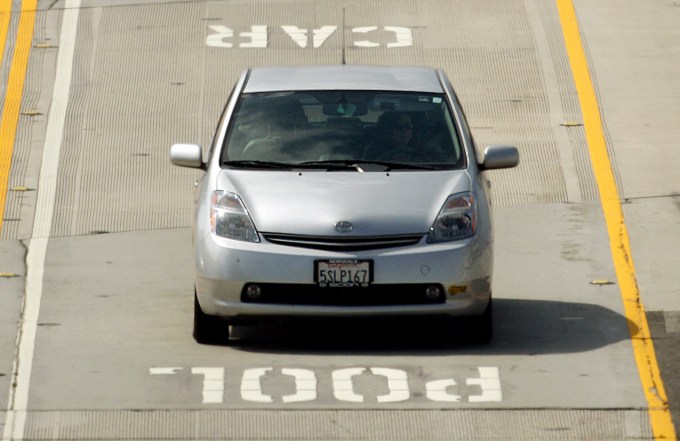 In a June 28, 2011 photo, a Toyota Prius hybrid auto bearing a California DMV decal on its left front bumper are seen in carpool lanes on Interstate 405 in Los Angeles.  The program that allowed single occupants of hybrids to use carpool lanes expires at the end of June. (AP Photo/Reed Saxon)