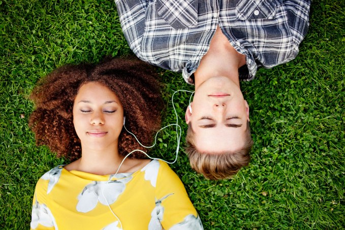 Young couple listening to and sharing music.