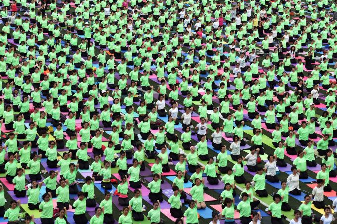 This photo taken on June 19, 2016 shows Chinese enthusiasts practicing yoga at Futian sports park in Shenzhen, south China's Guangdong province.    June 21 marks the International Yoga Day.  (Photo: STR/AFP/Getty Images)