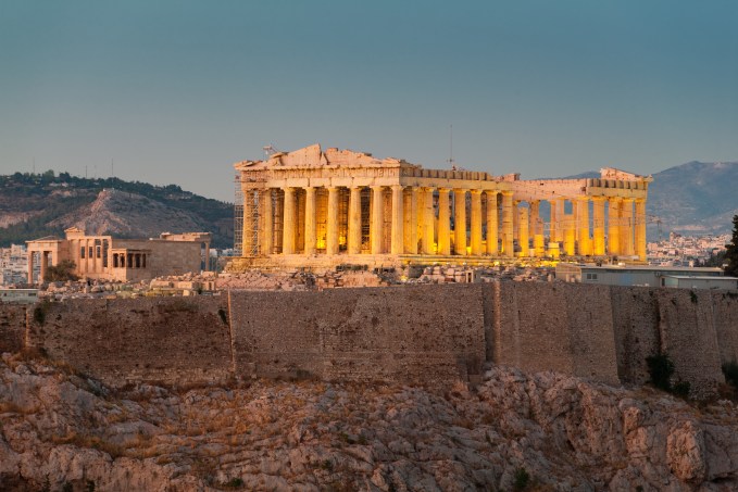 The illuminated ancient Greek Parthenon temple on the Acropolis of Athens at dusk.