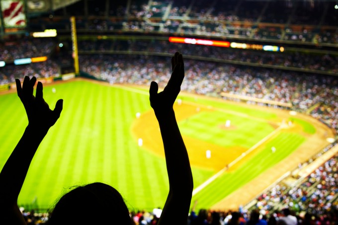 Silhouette of Baseball fan waving hands in the air