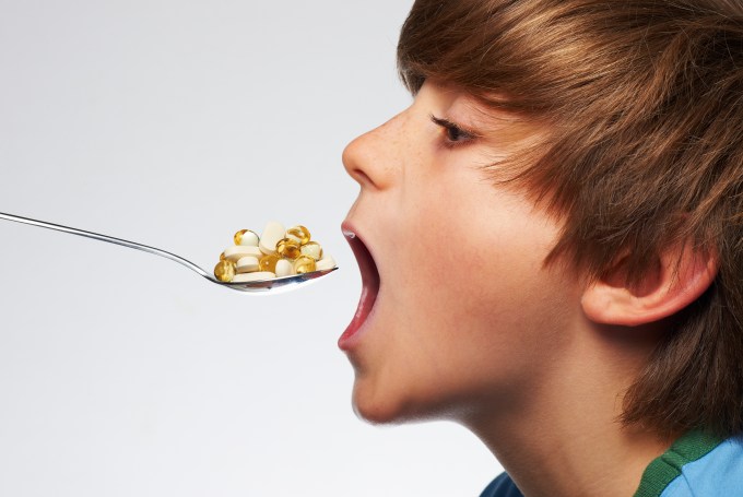 Boy(9 yrs) poised to eat spoonful of vitamins
