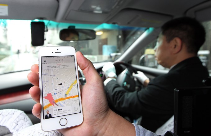 An Uber Japan Co. employee holds an Apple Inc. iPhone 5s showing a map on the Uber application for a photograph during a demonstration in Tokyo, Japan, on Wednesday, March 5, 2014. Uber Technologies Inc., the booking-app developer backed by Google Inc.s investment arm and Amazon.com Inc. founder Jeff Bezos, expanded to Tokyo using licensed taxi operators rather than private drivers. Photographer: Junko Kimura-Matsumoto/Bloomberg via Getty Images