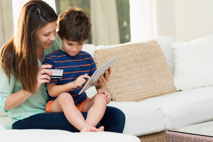 Mother and son (4-5) using tablet pc to make online purchases