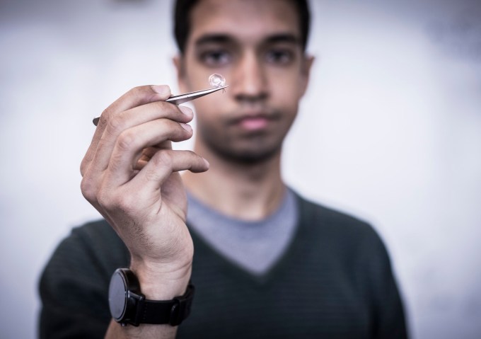 UW grad student Vikram Iyer holds a contact lens antenna that could use interscatter to communicate.