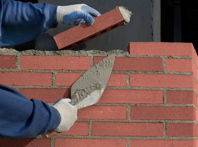 Hand of worker laying bricks, close-up