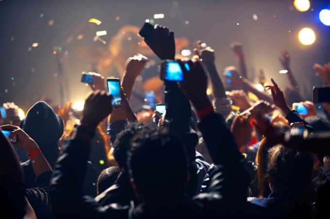 Fans hold up their phones during a concert