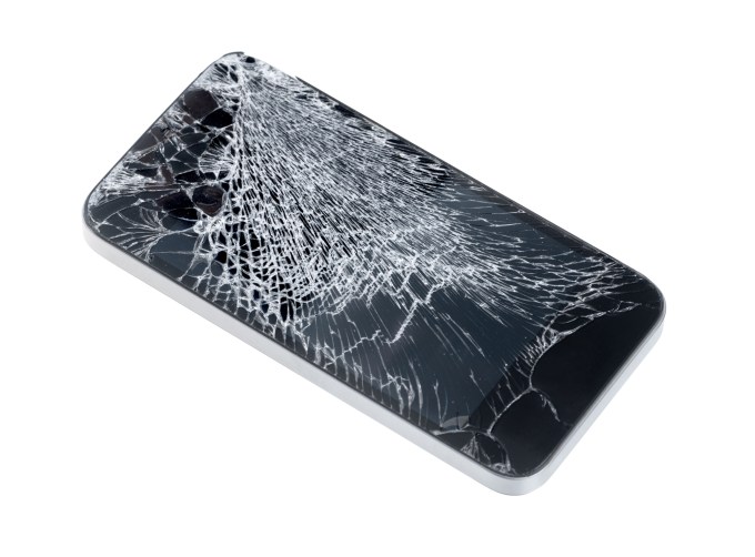 Mobile phone with shattered glass screen on white background
