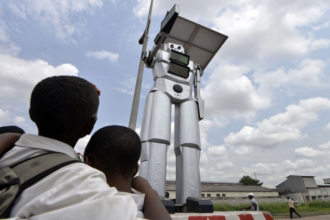 This picture taken on January 22, 2014 shows a traffic robot cop on Triomphal boulevard of Kinshasa at the crossing of Asosa, Huileries and Patrice Lubumba streets. Two human-like robots were recently installed here to help tackle the hectic traffic usually experienced in the area. The prototypes are equipped with four cameras that allow them to record traffic flow, the information is then transmitted to a center where traffic infractions can be analyzed. The team behind the new robots are a group of Congolese engineers based at the Kinshasa Higher Institute of Applied Technique, known by its French acronym, ISTA. (Photo: Junior D. Kannah/AFP/Getty Images)
