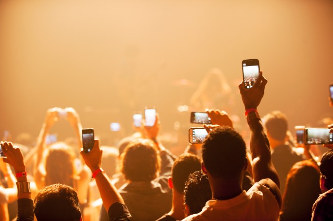 Fans using smartphones at a concert