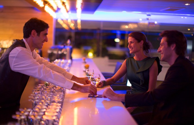 Couple receiving drinks from a barman in a hotel bar