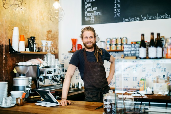 Young man with dreadlocks working as barista
