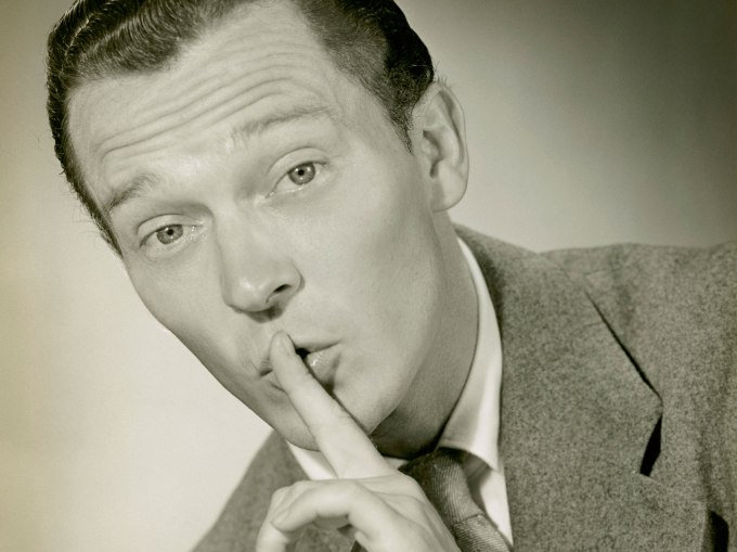 UNITED STATES - CIRCA 1950s:  Man covering lips with pointer finger.