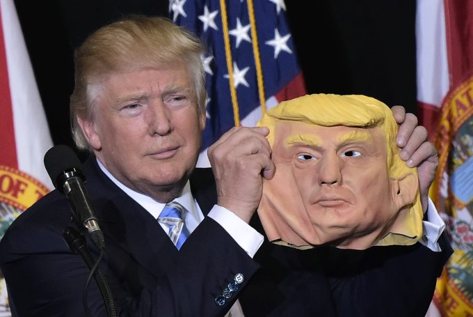 TOPSHOT - Republican presidential nominee Donald Trump holds a mask of himself which he picked up from supporter during a rally in the Robarts Arena of the Sarasota Fairgrounds on November 7, 2016 in Sarasota, Florida.Hillary Clinton and Donald Trump launched into the frenzied final day of their historic fight for the White House Monday, with blow-out rallies in the handful of swing states that will decide who leads the United States.    (Photo: MANDEL NGAN/AFP/Getty Images)