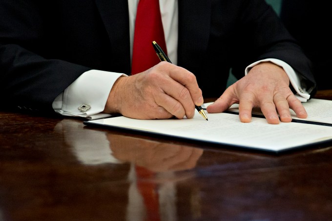 WASHINGTON, DC - JANUARY 30: U.S. President Donald Trump signs an executive order in the Oval Office of the White House January 30, 2017 in Washington, DC. Trump said he will "dramatically" reduce small business regulations overall with this executive action. (Photo by Andrew Harrer - Pool/Getty Images)