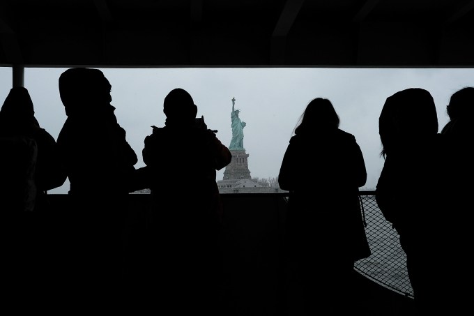 NEW YORK, NY - JANUARY 31: People headed to Ellis Island look out at the Statue of Liberty as it stands in New York Harbor in the snow on January 31, 2017 in New York City. With President Donald Trump's executive order on immigration, the subject of who can come to America has once again become a hotly debated topic in the country. The executive order temporarily bars immigrants from Iraq, Iran, Yemen, Somalia, Sudan, and Libya, and indefinitely prevents all Syrian refugees, from entering the U.S.  (Photo by Spencer Platt/Getty Images)